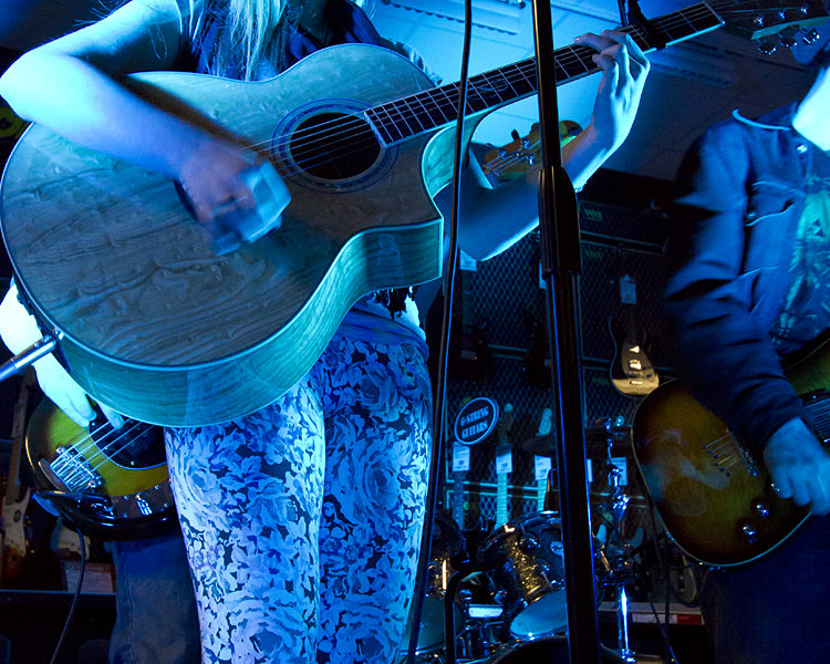 Student Acoustic Guitar Performance A Triumph guitar student performs on her acoustic guitar.